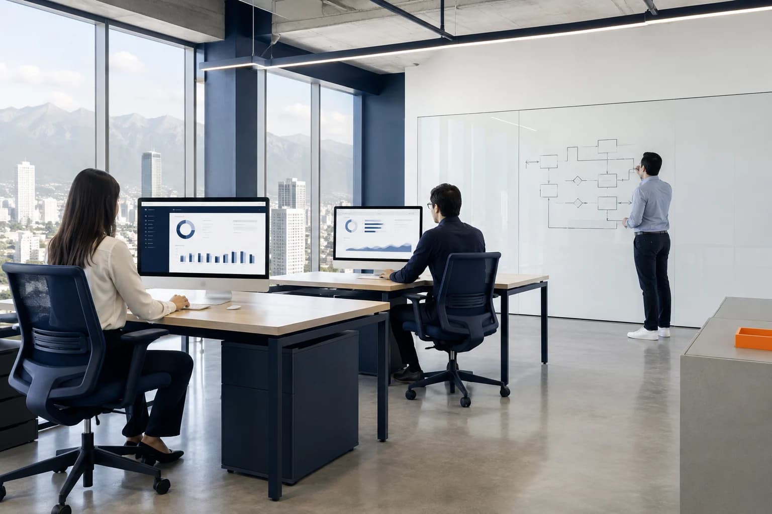 Equipo administrativo trabajando en una oficina de Monterrey, con la sierra al fondo